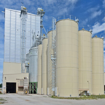 multiple silos next to a warehouse